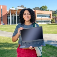 Mercedes Bracey with a laptop in front of the Student Center.